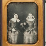 Two sisters in similar plaid dresses, 1850s