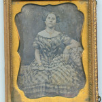 Lady in off-shoulder plaid dress, ca. 1850s