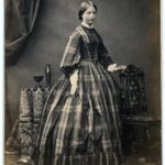 Young woman in plaid dress, 1860s