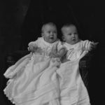 Two babies in white dresses, 1911