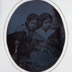 Two girls in identical dresses with a doll, ca. 1851