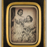 Two young women in floral dresses, 1850s